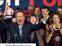 With his wife Karen at his side Republican presidential candidate Ohio Gov. John Kasich cheers with supporters Tuesday, Feb. 9, 2016, in Concord, N.H., at his primary night rally. (AP Photo/Jim Cole)