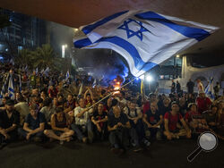 People block a road as they protest, calling for a deal for the immediate release of hostages held in the Gaza Strip by Hamas, in Tel Aviv, Israel, Sunday, Sept. 1, 2024. (AP Photo/Ohad Zwigenberg)