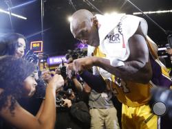 Los Angeles Lakers' Kobe Bryant, right, fist-bumps his daughter Gianna after the last NBA basketball game of his career, against the Utah Jazz on Wednesday, April 13, 2016, in Los Angeles.Bryant scored 60 points as the Lakers won 101-96. (AP Photo/Jae C. Hong)