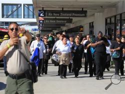 Passengers are directed outside Terminal 2 at Los Angeles International Airport on Friday Nov. 1, 2013, after shots were fired, prompting authorities to evacuate a terminal and stop flights headed for the city from taking off from other airports. (AP Photo/Ringo H.W. Chiu)