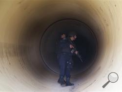Federal police inspect a drainage pipe outside the Altiplano maximum security prison in Almoloya, west of Mexico City, Sunday, July 12, 2015. (AP Photo/Marco Ugarte)