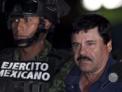 Mexican drug lord Joaquin "El Chapo" Guzman, right, is escorted by soldiers and marines to a waiting helicopter, at a federal hangar in Mexico City, Friday, Jan. 8, 2016. The world's most wanted drug lord was recaptured by Mexican marines Friday, six months after he fled through a tunnel from a maximum security prison in an escape that deeply embarrassed the government and strained ties with the United States.(AP Photo/Marco Ugarte)