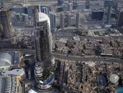 In this Sunday, Jan. 10, 2016 photo, the burned hulk of The Address Downtown is seen in Dubai, United Arab Emirates. Skyscraper fires like the blaze that struck the 63-story luxury hotel in Dubai on New Year’s Eve, swiftly turning it into a towering inferno, are not that rare. The New Year's Eve tower fire in Dubai has raised new issues about the safety of exterior sidings put on high-rise buildings in the United Arab Emirates and around the world. (AP Photo/Jon Gambrell)