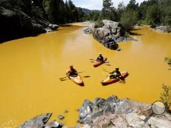 People kayak in the Animas River near Durango, Colo., Thursday, Aug. 6, 2015, in water colored from a mine waste spill. (Jerry McBride/The Durango Herald via AP)