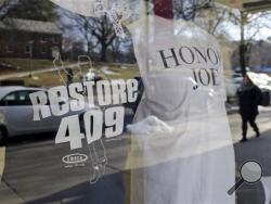 T-shirts displayed in the window of the Penn State Student Bookstore, Friday, Jan. 16, 2015, in State College, Pa., honor the 409 career coaching wins of former Penn State head football coach Joe Paterno. The NCAA announced Friday a settlement with the univeristy that will give the school back 112 wins wiped out during the Jerry Sandusky child molestation scandal and restore Paterno as the winningest coach in major college football history. (AP Photo/Gene J. Puskar)