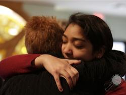Nikita Deep, 16, embraces a family friend at Antigo United Methodist Church following a morning service Sunday, April 24, 2016, in Antigo, Wis. According to police Jakob E. Wagner, 18, opened fire with a high-powered rifle outside of the a prom at Antigo High School late Saturday. Deep is class president at the school and was involved in the coordination of the prom. (Jacob Byk/The Marshfield News-Herald via AP) 