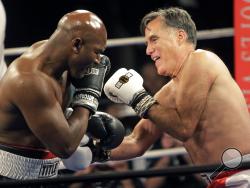 Former Republican presidential candidate Mitt Romney, right, throws punches with five-time heavyweight boxing champion Evander Holyfield at a charity fight night event Friday, May 15, 2015, in Salt Lake City. (AP Photo/Rick Bowmer)