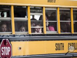 A Townville Elementary student looks out of the window of a school bus as she and her classmates are transported to Oakdale Baptist Church, following a shooting at Townville Elementary in Townville Wednesday, Sept. 28, 2016. A teenager killed his father at his home Wednesday before going to the nearby elementary school and opening fire with a handgun, wounding two students and a teacher, authorities said. (Katie McLean/The Independent-Mail via AP)