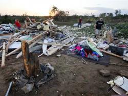 Friends and family of Lisa Buckner, not pictured, help to clean up after a tornado destroyed Buckner's home west of Wynnewood, Okla., in rural Gavin County, Monday, May 9, 2016. Storms swept through the nation's midsection Monday, spawning numerous tornadoes. (Nate Billings/The Oklahoman via AP) 