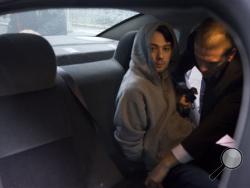 Martin Shkreli, the former hedge fund manager under fire for buying a pharmaceutical company and ratcheting up the price of a life-saving drug, is belted into an awaiting car after being taken into custody following a securities probe, on Thursday, Dec. 17, 2015 in New York. A seven-count indictment unsealed in Brooklyn federal court Thursday charged Shkreli with conspiracy to commit securities fraud, conspiracy to commit wire fraud and securities fraud. (AP Photo/Craig Ruttle)
