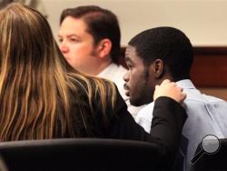 A member of the defense team put her hand on De'Marquise Elkins' shoulder as he was found guilty of all charges at Cobb Superior Court in Marietta, Ga. on Friday, Aug. 2013. Jurors deliberated about two hours before finding Elkins guilty of 11 counts, including two counts of felony murder and one count of malice murder in the March 21 killing of 13-month-old Antonio Santiago in Brunswick. (AP Photo/Atlanta Journal-Constitution, Phil Skinner)