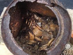 This image provided by the Saddle Ridge Hoard discoverers via Kagin's, Inc., shows one of the six decaying metal canisters filled with 1800s-era U.S. gold coins unearthed in California by two people who want to remain anonymous. The value of the "Saddle Ridge Hoard" treasure trove is estimated at $10 million or more. (AP Photo/Saddle Ridge Hoard discoverers via Kagin's, Inc.)