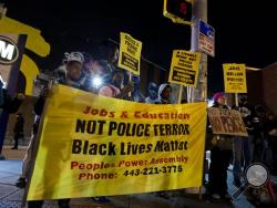 Demonstrators peacefully protest at the intersection of North and Pennsylvania Avenues, Wednesday, Dec. 16, 2015, in Baltimore, the site of unrest following the funeral of Freddie Gray. Peaceful protests took place in response to a hung jury and mistrial for Officer William Porter, one of six Baltimore city police officers charged in connection to Gray's death. (AP Photo/Jose Luis Magana)