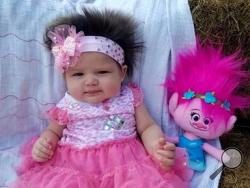 This Nov. 1, 2016 photo provided by Alisha John shows her daughter, Areea John, in Elton, La. John says her 3-month-old daughter has such a full head of hair that strangers stop to admire it, and she dressed the baby as a troll for Halloween. But John tells the American Press that she and her husband, Dakota John, don’t have long to play with baby Areea’s hair. That’s because Dakota John is a member of the Coushatta Indian tribe, which shaves babies’ heads as part of a blessing ceremony when they’re four mo