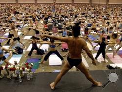 In this Sept. 27, 2003, file photo, Bikram Choudhury, front, founder of the Yoga College of India and creator and producer of Yoga Expo 2003, leads what organizers hope will be the world's largest yoga class at the Los Angeles Convention Center. (AP Photo/Reed Saxon, File)