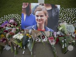 An image and floral tributes for Jo Cox, lay on Parliament Square, outside the House of Parliament in London, Friday, June 17, 2016, after the 41-year-old British Member of Parliament was fatally injured Thursday in northern England. The mother of two young children was shot to death Thursday afternoon in her constituency near Leeds. A 52-year-old man has been arrested but has not been charged. He has been named locally as Tommy Mair. (AP Photo/Matt Dunham)