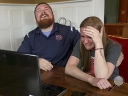 In this Monday, April 6, 2015 photo, Joel Burger and Ashley King react at King’s home in New Berlin, Ill., after learning from a New York public relations firm that Burger King has offered to pay the expenses and provide gifts for their wedding because of their interesting connection to the fast food restaurant chain. (AP Photo/The State Journal-Register, David Spencer)
