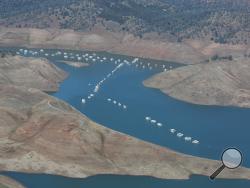 In this aerial photo taken Tuesday, April 28, 2015, house boats sit in the receding waters of New Hogan Lake near Valley Springs, east of Lodi, Calif. (AP Photo/Rich Pedroncelli)