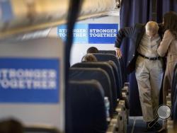 Hillary Clinton's campaign manager John Podesta, second from right, speaks with senior aide Huma Abedin, right, aboard Clinton's campaign plane while traveling to Miami, Tuesday, Oct. 11, 2016, for a rally. (AP Photo/Andrew Harnik)
