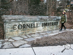 A woman walks by a Cornell University sign on the Ivy League school's campus in Ithaca, New York, on Friday, Jan. 14, 2022. (AP Photo/Ted Shaffrey, File)