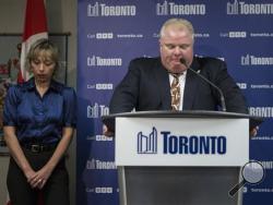 Toronto Mayor Rob Ford stands with his wife Renata at a news conference on Thursday. Ford has apologized for making crude comments in responding to allegations contained in court documents. Ford said the "graphic" remarks came after six months of relentless pressure. He said "revelations" of cocaine, escorts and prostitution made public Wednesday had pushed him "over the line." He called the allegations "100 percent lies." (AP Photo/The Canadian Press, Chris Young)