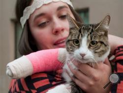 Stephanie Gustafson holds her two-year-old female cat, Wasabi, after returning from the veterinarian hospital in Juneau, Alaska. The cat survived a fall from the 11th floor of the Mendenhall Apartment building after chasing a mosquito out the window. (AP Photo/The Juneau Empire, Michael Penn)
