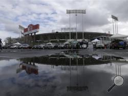 O.co Coliseum is reflected in a puddle before an NFL football game between the Oakland Raiders and the San Diego Chargers in Oakland, Calif., Thursday, Dec. 24, 2015. The Raiders could be moving to the Los Angeles area after the season. Raiders owner Mark Davis and Chargers owner Dean Spanos are seeking to partner on building a stadium in Carson. (AP Photo/Jeff Chiu)
