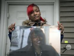 Latonya Jones, 19, holds a photo of her mother, Bettie Jones, during a vigil on Sunday, Dec. 27, 2015, in Chicago. Jones and Quintonio LeGrier, 19, were killed early Saturday by police responding to a domestic disturbance on the city’s West Side, police said. (Ashlee Rezin/Chicago Sun-Times via AP)