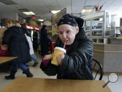 In this Tuesday March 3, 2015 photograph, Charla Nash drinks a cup of hot coffee through a straw while visiting a cafe in Boston. (AP Photo/Charles Krupa)