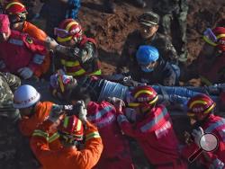In this photo provided by China's Xinhua News Agency, a survivor is found at the site of landslide at an industrial park in Shenzhen, south China's Guangdong Province, early Wednesday, Dec. 23, 2015. Rescuers have pulled a man out alive after he was buried for more than 60 hours in a massive landslide in southern China. (Jin Liangkuai/Xinhua News Agency via AP)