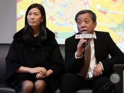 In this Dec. 18, 2014 photo, Chinese billionaire and art collector Liu Yiqian, right, and his wife Wang Wei, left, attend an opening ceremony in Shanghai, China for the exhibition of a $36 million Ming Dynasty tea cup he bought and paid for with his American Express card. (Chinatopix via AP)