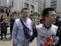 Sun Wenlin, right, and his partner Hu Mingliang leave the court after a judge ruled against them in China's first gay marriage case in Changsha in central China's Hunan province on Wednesday, April 13, 2016. A judge on Wednesday ruled against the gay couple in China's first same-sex marriage case that attracted several hundred cheering supporters to the courthouse and was seen as a landmark moment for the country's emerging LGBT rights movement. (AP Photo/Gerry Shih)