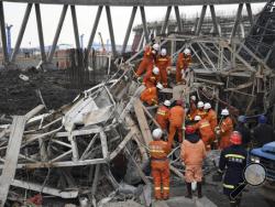 In this photo released by Xinhua News Agency, rescue workers look for survivors after a work platform collapsed at the Fengcheng power plant in eastern China's Jiangxi Province, Nov. 24, 2016. State media reported dozens were killed after the scaffolding tumbled down. (Wan Xiang/Xinhua via AP)