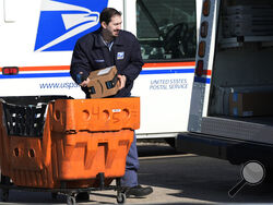 FILE - A U.S. Postal Service employee loads parcels outside a post office in Wheeling, Ill., on Jan. 29, 2024. (AP Photo/Nam Y. Huh, File)