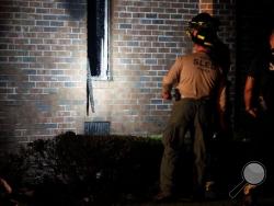 Members of the South Carolina Law Enforcement Division examine the remains of the Mount Zion African Methodist Episcopal church, early Wednesday, July 1, 2015, in Greeleyville, S.C. The African-American church, which was burned down by the Ku Klux Klan in 1995, caught fire Tuesday night, June 30, 2015. (Veasey Conway/The Morning News via AP)