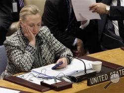 In this March 12, 2012 file photo, then-Secretary of State Hillary Rodham Clinton checks her mobile phone after her address to the Security Council at United Nations headquarters. An impromptu meeting between Bill Clinton and the nation's top cop could further undermine Hillary Clinton’s efforts to convince voters to place their trust in her, highlighting perhaps her biggest vulnerability. (AP Photo/Richard Drew, File)