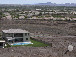 FILE - A home with a swimming pool abuts the desert on the edge of the Las Vegas valley July 20, 2022, in Henderson, Nev. Nevada lawmakers on Monday, March 13, 2023, will consider another shift in water use for one of the driest major metropolitan areas in the U.S. The water agency that manages the Colorado River supply for Vegas is seeking authority to limit what comes out of residents' taps. (AP Photo/John Locher, File)