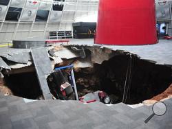 In this image provided by the National Corvette Museum shows several cars that collapsed into a sinkhole Wednesday, Feb. 12, 2014, in Bowling Green, Ky. The museum said a total of eight cars were damaged when a sinkhole opened up early Wednesday morning inside the museum. (AP Photo/National Corvette Museum, HO)