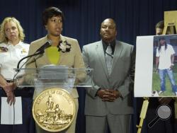 Washington Mayor Muriel Bowser, center, flanked by Police Chief Cathy Lanier, left, and Special Agent in Charge Charlie Smith, Bureau of Alcohol, Tobacco, Firearms and Explosives, speaks during a news conference in Washington, Thursday, May 21, 2015, on the investigation into the mysterious slayings of a wealthy Washington family and their housekeeper. (AP Photo/Cliff Owen)