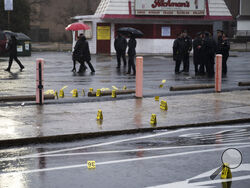 Evidence markers are seen following a shooting in Northeast Philadelphia on Wednesday, March 6, 2024. Four shootings over four days in Philadelphia left three dead and 12 injured, many of them children — violence that put renewed focus on safety within the sprawling mass transit system and gave ammunition to critics of the city's progressive chief prosecutor. (AP Photo/Joe Lamberti)