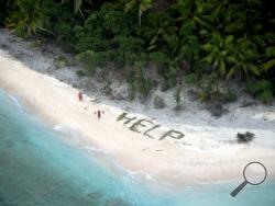 This photo provided by U.S. Navy released April 7, 2016 shows two men waving life jackets and look on as a U.S. Navy P-8A maritime surveillance aircraft discovers them on the uninhabited island of Fanadik. The three men were back to safety on Thursday, April 7, 2016, three days after going missing. (U.S. Navy/Ensign John Knight via AP)