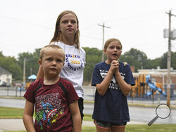 Hudson, 7, left, Callahan, 13, middle, and Keegan Pruente, 10, right, stand outside their school on their first Monday home during the new four-day school week on Monday, Sept. 11, 2023, in Independence, Mo. Hundreds of school systems around the country have adopted four-day weeks in recent years, mostly in rural and western parts of the U.S. Districts cite cost savings and advantages for teacher recruitment. Still, some experts question the effects on students who already missed out on significant learning