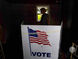 FILE - A person waits in line to vote in the Georgia's primary election on May 24, 2022, in Atlanta. A new poll shows 71% of voters think the future of the country is at stake when they vote in November's midterm elections. That's according to a new poll from The Associated Press-NORC Center for Public Affairs Research. (AP Photo/Brynn Anderson, File)