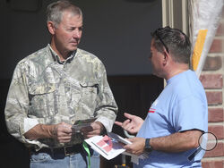 Bob Schmidt, right, a Republican voter, talks to state Rep. Jesse Borjon, left, R-Topeka, outside the garage of Schmidt’s home, Saturday, Oct. 5, 2024, in Topeka, Kansas. (AP Photo/John Hanna)