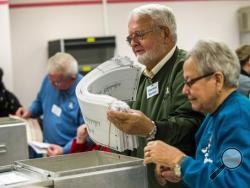 Election workers recount votes on Flint ballots, as they begin the process of a statewide recount on Wednesday, Dec. 7, 2016 at Genesee County Administration Building in Flint, Mich. A federal judge could decide whether to end Michigan's presidential recount after the state's second-highest court said the Green Party nominee was ineligible to seek a second look at millions of ballots. (Jake May/The Flint Journal-MLive.com via AP)