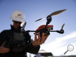 Long-awaited rules to usher in a new era in which small, commercial drones zipping through U.S. skies are a part of everyday life were proposed by the Federal Aviation Administration on Sunday, Feb. 15, 2015. (AP Photo/Gregory Bull, File)