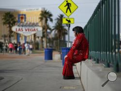 In this March 3, 2016, photo, Ted Payne rests as he works for tips dressed as Elvis at the "Welcome to Las Vegas" sign in Las Vegas. For decades, Las Vegas has loved Elvis Presley. But the King's presence in modern day Sin City has lately been diminishing. (AP Photo/John Locher)