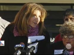 n this Jan. 5, 2016 still image from WJAR-TV video, Sue Stenhouse, left, executive director of the Senior Enrichment Center, speaks alongside a man dressed as an elderly woman, right, during a news conference in Cranston, R.I., to promote a program for school children to help senior citizens shovel snow during the winter. (WJAR-TV via AP) 