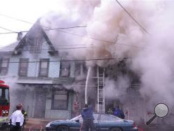 Smoke billows from the front of the homes on South Rock Street in Shamokin, Pa. that were destroyed five homes and took the life of a 13 year old female on Tuesday, Dec. 10, 2013. (AP Photo/The News-Item, Mike Staugaitis)