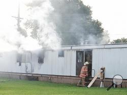 Firefighters extinguish a mobile home fire Sunday, Sept. 15, 2013, that killed a man and five children in Tiffin, Ohio, according to police. Fire crews pulled the man and the children from the home, and all six were taken to Tiffin Mercy Hospital, where they were pronounced dead. The fire was reported shortly before 8 a.m. Sunday in a mobile home park in Tiffin, about 50 miles southeast of Toledo, Ohio. (AP Photo/Advertiser-Tribune, Jill Goshe)